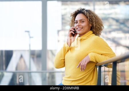 Ritratto di sorridente afroamericana che parla con il cellulare Foto Stock