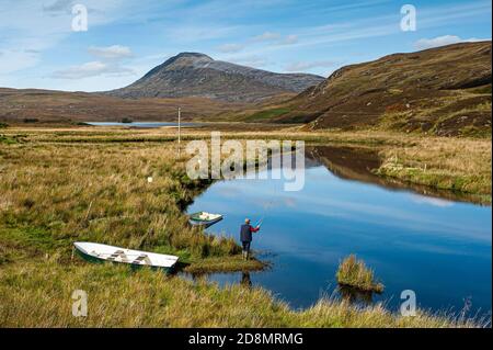 Pesca a mosca per la trota marrone sul fiume Ledmore tra Ullapool e Lochinver nel parco di Assynt Geo in Sutherland Scozia. Foto Stock