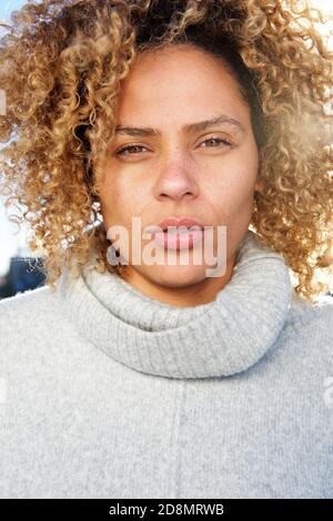 Primo piano ritratto di bella giovane donna afroamericana con capelli ricci fissando Foto Stock