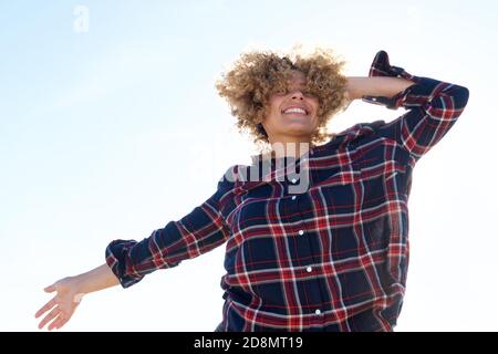 Ritratto di felice giovane afroamericana che ride con la mano all'esterno dei capelli Foto Stock