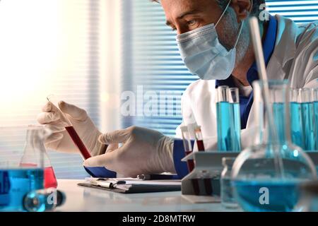 Tecnico medico di laboratorio che analizza campioni di sangue in sala di analisi. Composizione orizzontale. Vista frontale. Foto Stock