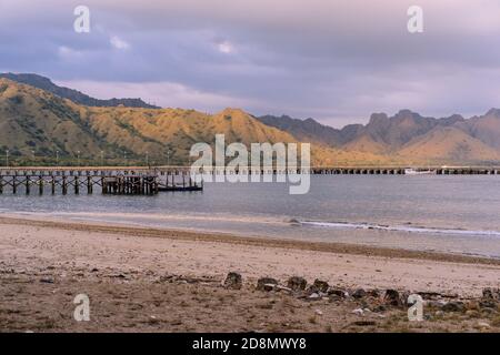 Baia di mare tra le montagne, molo sull'isola di Komodo, ingresso al parco nazionale dell'UNESCO in Indonesia, cielo spettacolare sulle colline e sul mare, bella Asia l Foto Stock