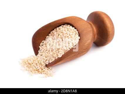 Semi di sesamo in paletta di legno, isolati su sfondo bianco. Semi secchi di sesamo organici. Foto Stock