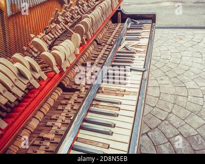 Un frammento di un vecchio pianoforte rotto con un muro mancante e tasti rotti. Foto con filtro applicato Foto Stock