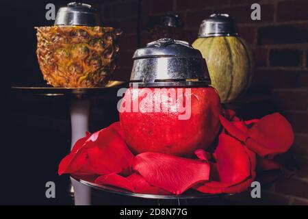 Shisha con coppa di frutta con fumo colorato in Hookah Bar Closeup. Foto Stock