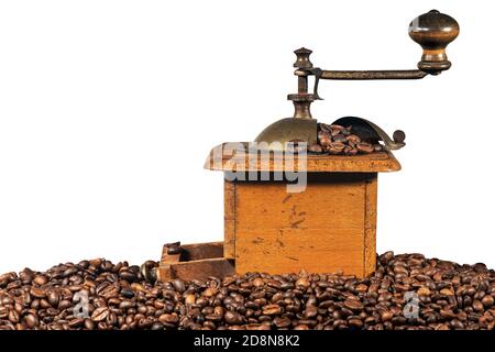 Vecchio macinacaffè manuale in metallo e legno con chicchi di caffè torrefatti isolati su sfondo bianco. Veneto, Italia, Europa. Foto Stock