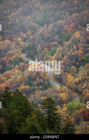 Strada tortuosa che si snoda attraverso i colori autunnali Foto Stock