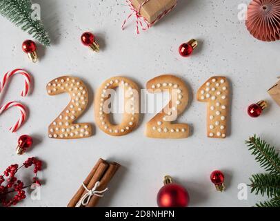 Biscotti di pan di zenzero sotto forma di numeri, pan di zenzero Capodanno 2021 e arredamento festivo su sfondo grigio. Vista dall'alto. Disposizione piatta Foto Stock