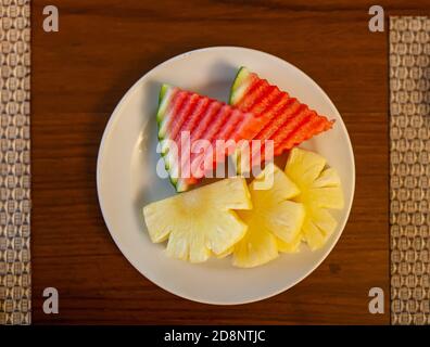Cocomero fresco e scivolo di ananas in piatto bianco. Foto Stock