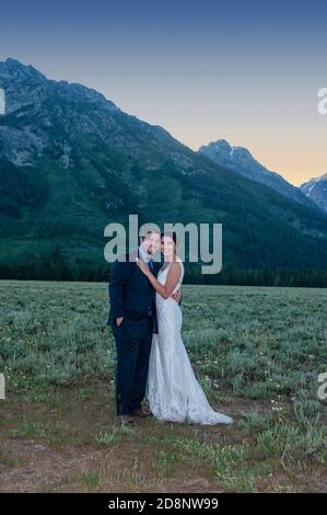 Yellowstone, Wyoming - 27 giugno 2016: Sposa e sposo di fronte alle Grand Teton Mountains nel Wyoming, Stati Uniti. Foto Stock