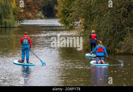 una famiglia paddle boarding sul fiume nel parco presso la spa royal leamington nel warwickshire Foto Stock