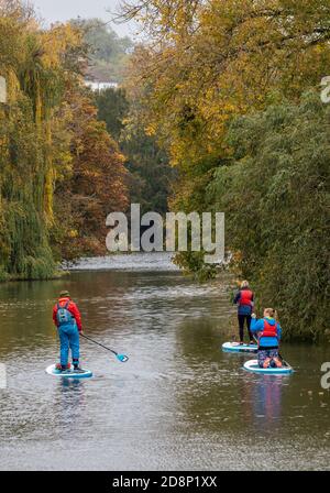 una famiglia paddle boarding sul fiume nel parco presso la spa royal leamington nel warwickshire Foto Stock