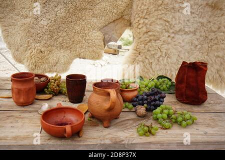 uva e frutta in ceramica ancora viva su fondo di pietra Foto Stock