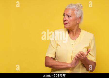 Donna ispanica anziana seria che guarda da parte sul copyspace Foto Stock