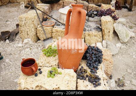 uva e frutta in ceramica ancora viva su fondo di pietra Foto Stock