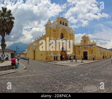 antigua, guatemala, 2019 agosto: Persone che camminano di fronte alla chiesa di iglesia de la merced in una giornata di sole. Foto Stock