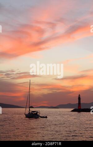 Seascape al tramonto. Faro sulla costa. Città balneare di Turgutreis e tramonti spettacolari Foto Stock