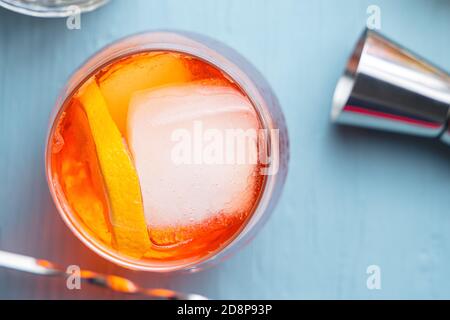 Bicchiere di classico cocktail spritz con aperitivo italiano e fetta di arancia come contorno su un tavolo blu. Vista dall'alto Foto Stock