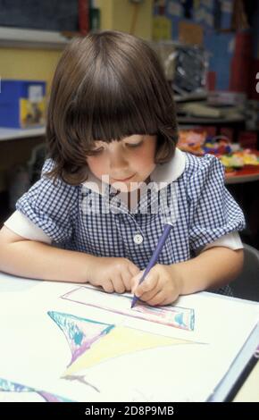 bambina in scuola primaria colorazione classe Foto Stock