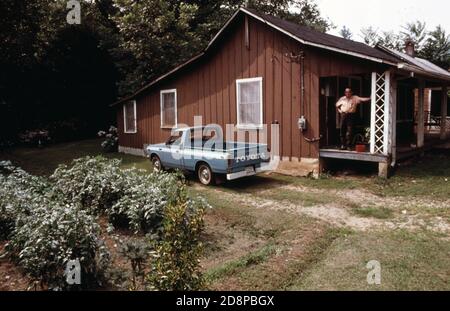 Casa su River Street; mezzo isolato a sud dei negozi di Main Street a Helen; Georgia; vicino a Robertstown. La città era tipica delle piccole comunità montane della zona fino al 1969, quando i residenti decisero di ristrutturare i negozi del quartiere degli affari con un tema alpino bavarese. Secondo un piano di crescita della comunità del 1975, nella zona centrale a sud di Main Street vivono 22 famiglie che saranno sfollate tra il 1975 e il 1990. Il proprietario della casa sul portico progetta vendere in un anno o due e lasciare la città Foto Stock