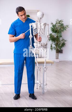 Docente medico maschile che dimostra scheletro Foto Stock