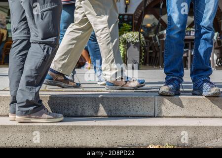 COBLENZA, GERMANIA - 19 settembre 2020: Gambe di un gruppo di uomini in piedi troppo vicini, nessuna distanza sufficiente per prevenire Corona/covid-19 Foto Stock