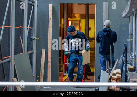 Manhattan, Stati Uniti. 31 Ott 2020. Operai di costruzione che mettono su barricate del legno compensato intorno al Fox News Building. Il 31 ottobre 2020, in preparazione di potenziali disordini legati alle elezioni, i rivenditori e le imprese, tra cui l'edificio di News Corporation, sede di Fox News, hanno iniziato a fortificare i loro locali con legno compensato, barriere metalliche, e sicurezza extra. (Foto di Michael Nigro/Sipa USA) Credit: Sipa USA/Alamy Live News Foto Stock