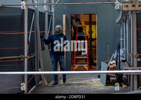 Manhattan, Stati Uniti. 31 Ott 2020. Operai di costruzione che mettono su barricate del legno compensato intorno al Fox News Building. Il 31 ottobre 2020, in preparazione di potenziali disordini legati alle elezioni, i rivenditori e le imprese, tra cui l'edificio di News Corporation, sede di Fox News, hanno iniziato a fortificare i loro locali con legno compensato, barriere metalliche, e sicurezza extra. (Foto di Michael Nigro/Sipa USA) Credit: Sipa USA/Alamy Live News Foto Stock