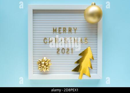 Cartellone con auguri natalizi 2021, decorazioni su sfondo blu pastello di girly. Composizione di Natale. Posa piatta, dall'alto Foto Stock