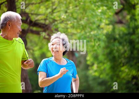 Asian Senior coppia jogging nel parco naturale Foto Stock