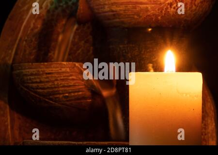 Acqua lentamente e dolcemente in caduta illuminata a lume di candela. Foto Stock