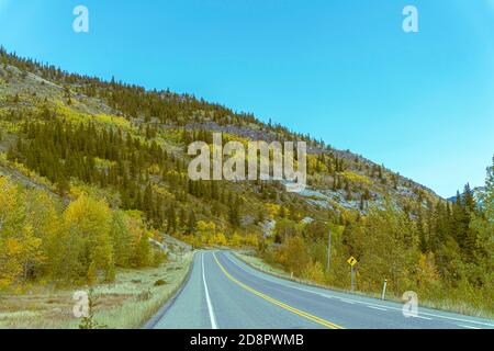 Strada rurale circondata da colline in Alberta Foto Stock