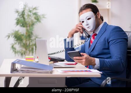 Dipendente con maschera in concetto di ipocrisia Foto Stock
