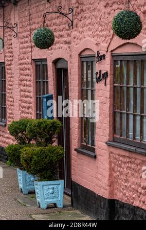 twee e graziosi cottage in un villaggio inglese dipinto in rosa brillante. Foto Stock