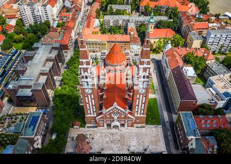 Szeged, Ungheria - veduta aerea dall'alto verso il basso della Chiesa Votiva e della Cattedrale di nostra Signora d'Ungheria (Szeged Dom) in una soleggiata giornata estiva Foto Stock