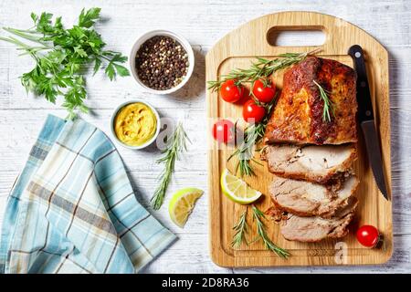 Filetto di maiale arrosto a fette: Un pezzo di carne di maiale strofinata con senape e spezie: Rosmarino, foglia di alloro, succo di lime cotto al forno servito su un taglio Foto Stock