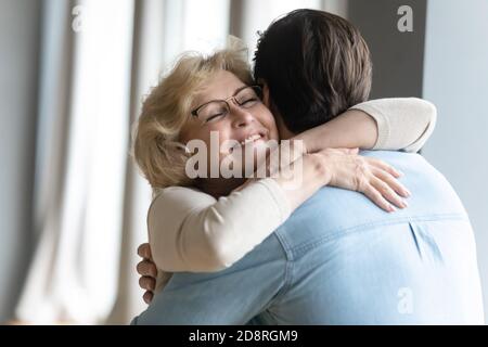 Giovane uomo premuroso che visita mummia matura in pensione. Foto Stock