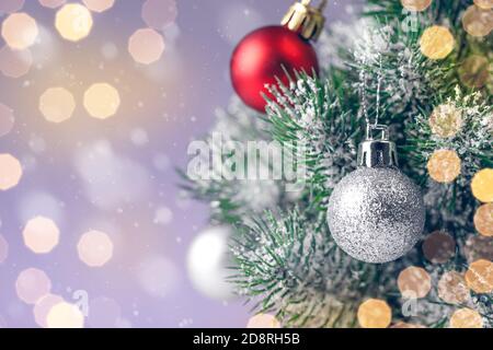 Albero di Natale decorato con giocattoli in argento e palline rosse su uno sfondo sfocato, frizzante e favoloso fata con bella bokeh Foto Stock