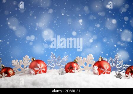 Fila di palle di Natale e fiocchi di neve che si stese su una neve Foto Stock