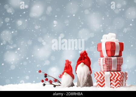 Gnomi di Natale con scatole regalo sullo sfondo della neve Foto Stock