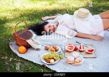 giovane bella bruna donna incinta all'aperto nel parco verde sorridente felice, avendo pic-nic, stile di vita concetto di persone Foto Stock