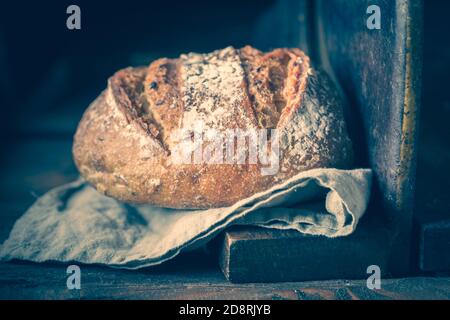 Primo piano di pane rustico su affettatrice vecchia Foto Stock