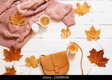 autunno still life, foglie gialle, zucca, candele, maglia maglione su sfondo bianco, vista dall'alto Foto Stock