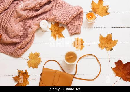 autunno still life, foglie gialle, zucca, candele, maglia maglione su sfondo bianco, vista dall'alto Foto Stock