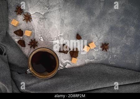 Composizione con tazza di caffè, zucchero e cioccolato su fondo scuro. Disposizione piatta, vista dall'alto Foto Stock
