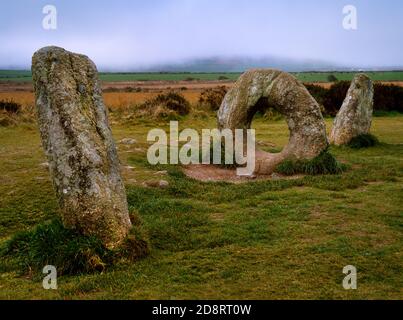 Visualizza SSW di uomini e pietra arcuata di Tol, Bosullow Common, West Penwith, Cornovaglia, Inghilterra, Regno Unito, associati con folklore, rituali di guarigione e divinazione. Foto Stock