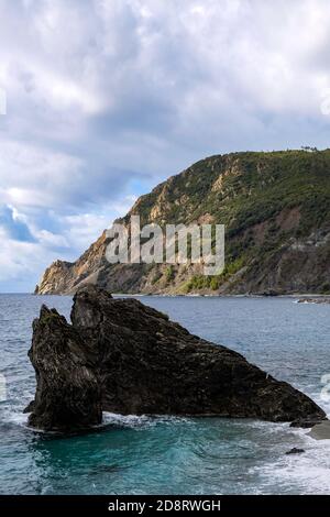 Formazione rocciosa su una spiaggia incontaminata di Pebble con splendide acque cristalline - Monterosso al Mare, cinque Terre, Italia Foto Stock