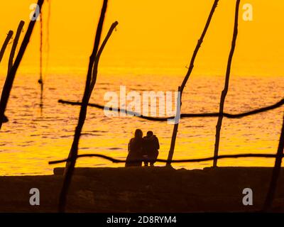 La giovane coppia teenager seduta insieme abbracciò la visione del tramonto all'orizzonte a Basanija vicino a Savudrija, Costa d'Istria in Croazia Europa Foto Stock