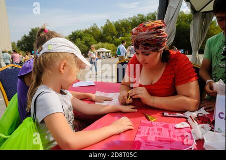 Bambina ottenere tatuaggio glitter. Tyumen. Russia Foto Stock