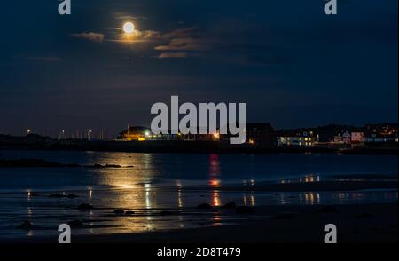 Hunter luna piena sorge sullo skyline di North Berwick con riflessi d'acqua, East Lothian, Scozia, Regno Unito Foto Stock